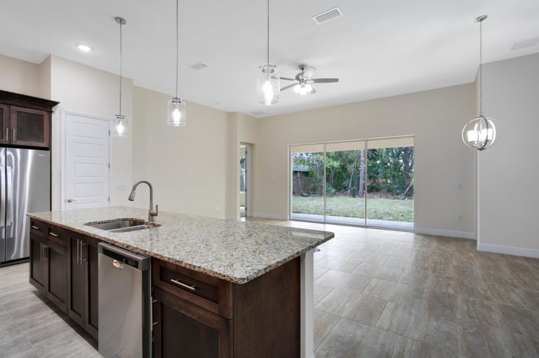 Kitchen island with wood cabinets and granite counters at 20478 Netherland Street, Wedgefield