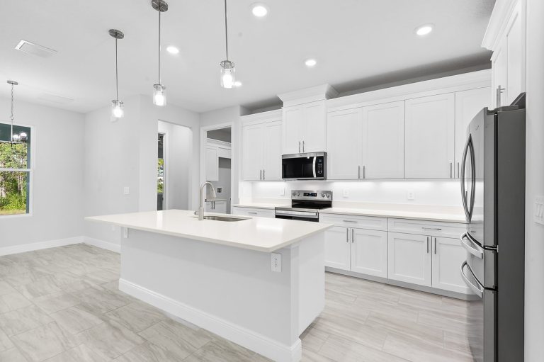 Kitchen with a center island, white cabinets and stainless steel appliances at 18743 Overton Street, Wedgefield